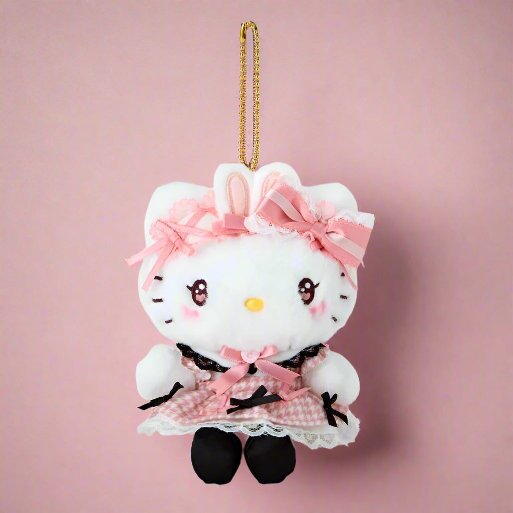 Plush keychain of a character with a white face, pink hair, and black dress on a white background