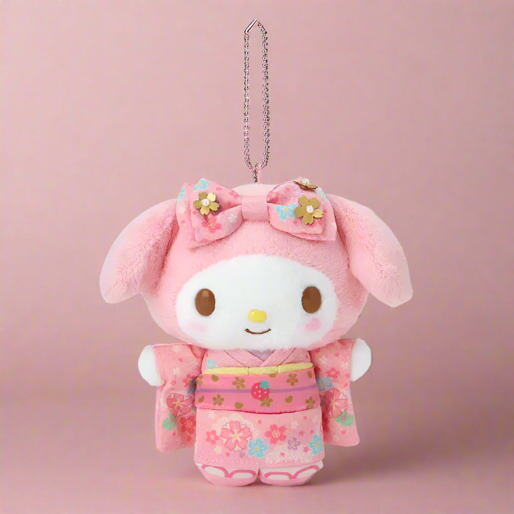 Plush keychain in pink outfit with floral design on a white background