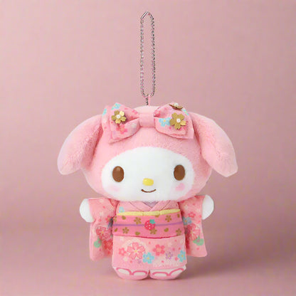 Plush keychain in pink outfit with floral design on a white background