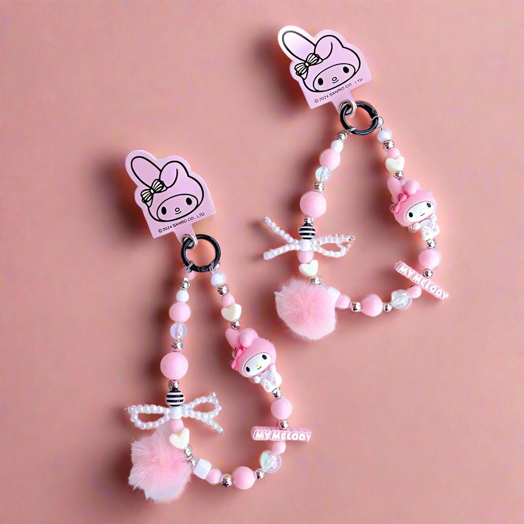 Pink beaded keychain with character design on a white surface