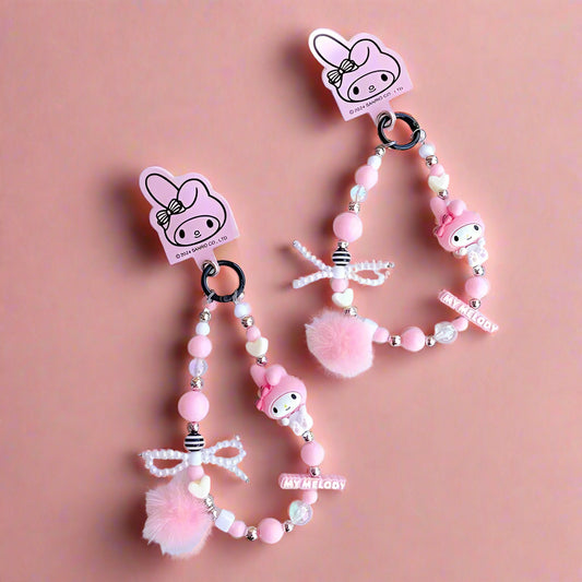 Pink beaded keychain with character design on a white surface