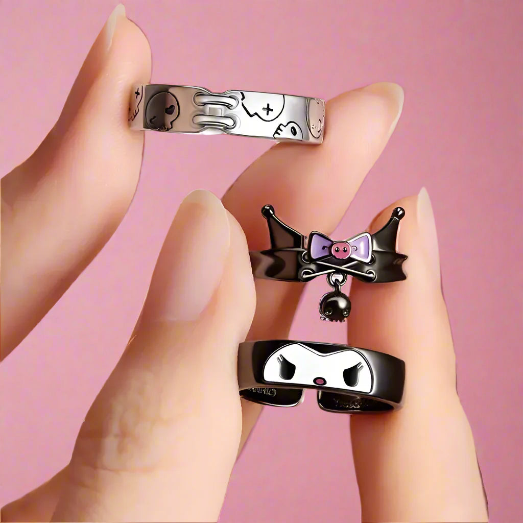Three decorative rings held by a hand against a light background