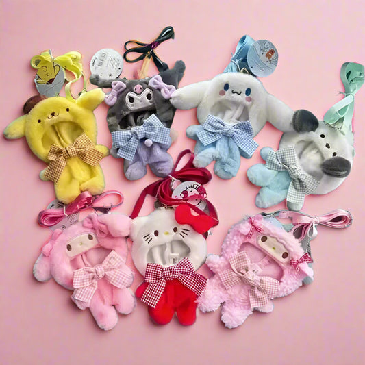Collection of small plush toys with bows on a gray surface