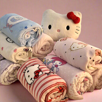 Collection of Hello Kitty-themed blankets on a couch with a decorative pillow.
