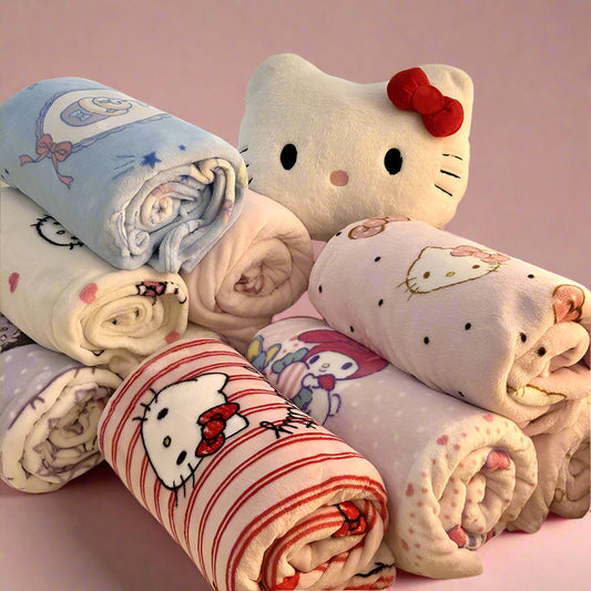 Collection of Hello Kitty-themed blankets on a couch with a decorative pillow.