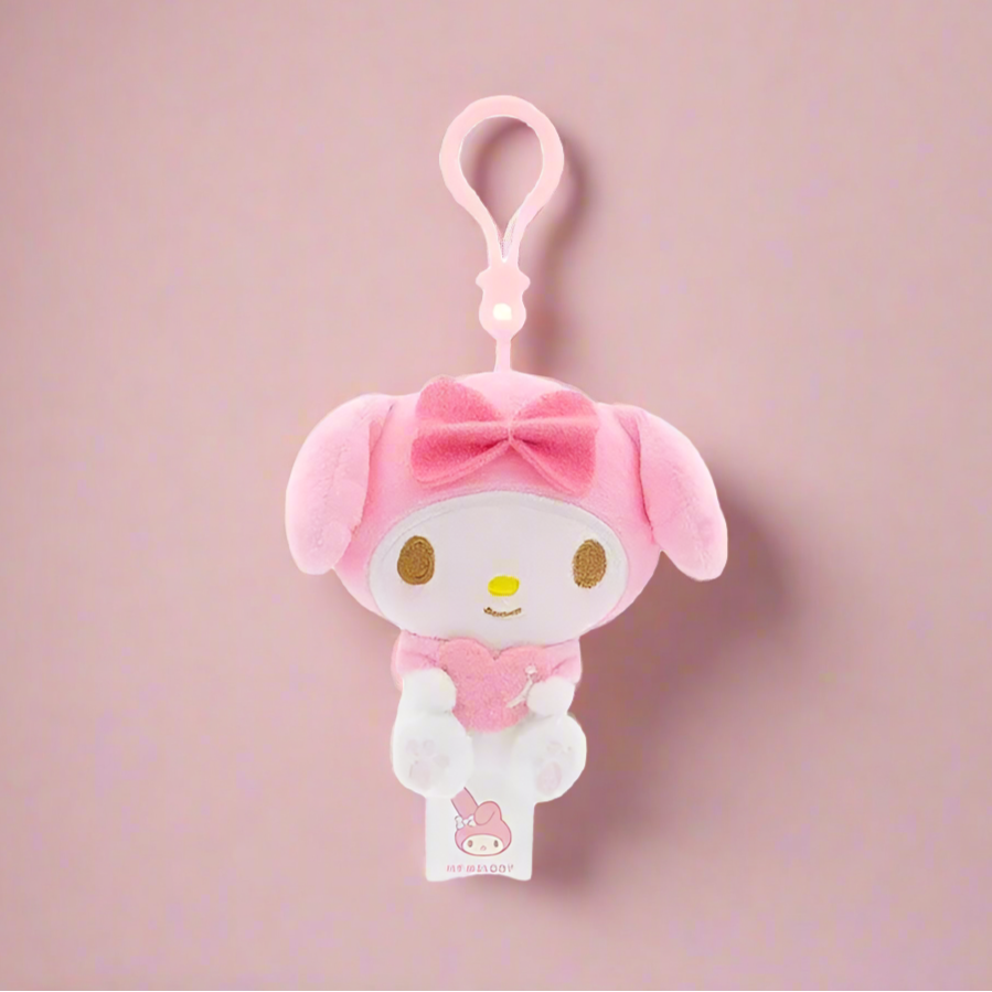 Two plush keychains featuring characters from Sanrio, one designed like a white cat with a blue heart and the other like a white bear with a red heart.