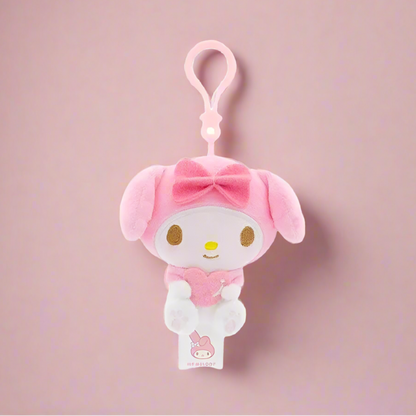 Two plush keychains featuring characters from Sanrio, one designed like a white cat with a blue heart and the other like a white bear with a red heart.