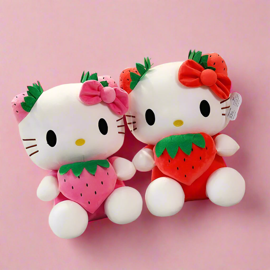 Two Hello Kitty plush toys with strawberry designs on a checkered tablecloth.