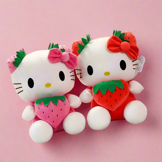 Two Hello Kitty plush toys with strawberry designs on a checkered tablecloth.