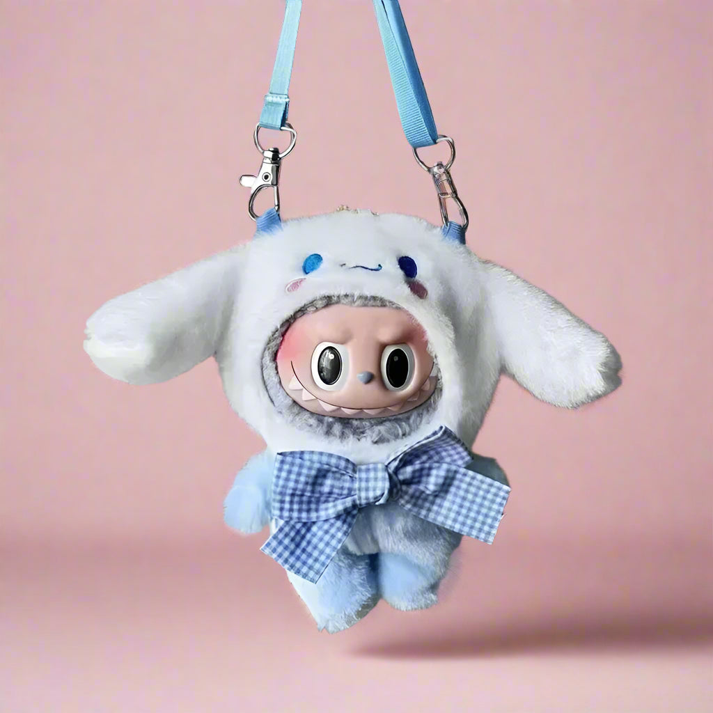 Plush keychain with cartoon character wearing a white hood and blue bow tie, hanging on a metal surface.
