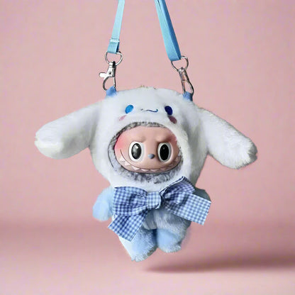 Plush keychain with cartoon character wearing a white hood and blue bow tie, hanging on a metal surface.