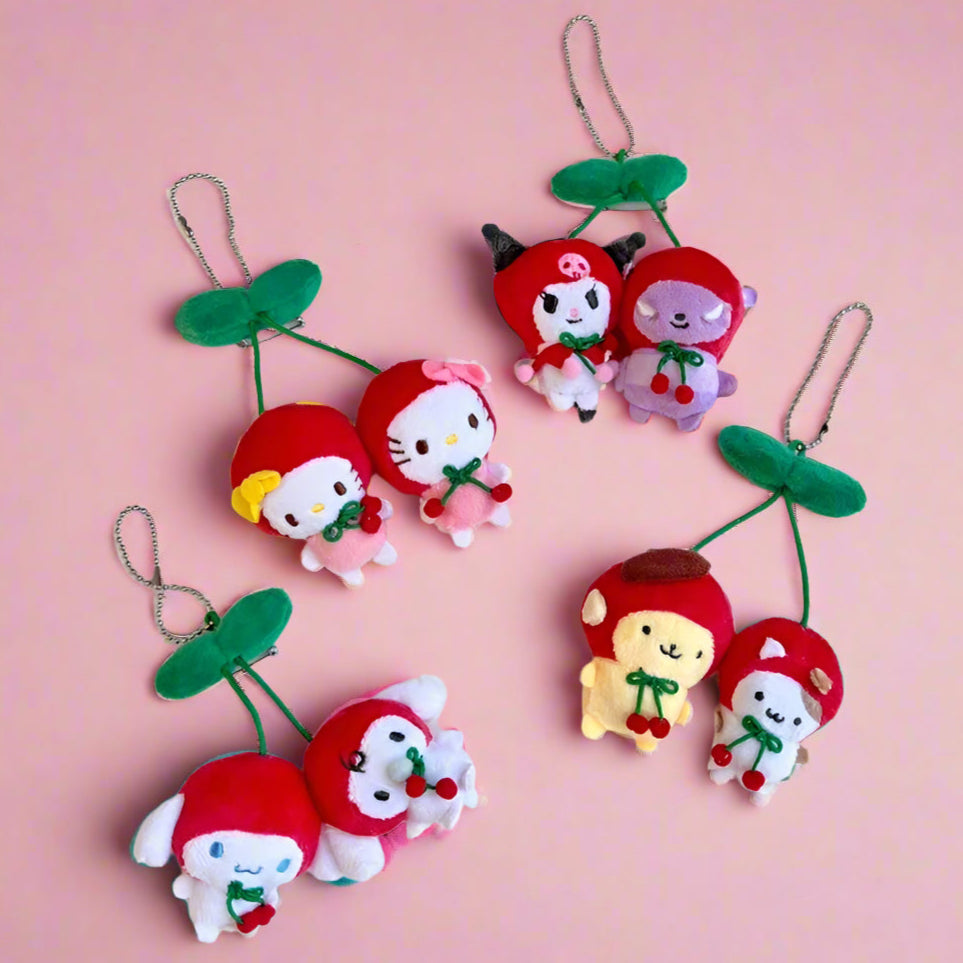 A collection of plush keychains featuring characters from the Sanrio 'Cherry' series, with red and green colors predominately used.