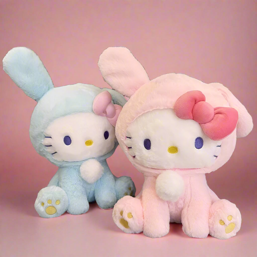 Two plushie toys, one in blue rabbit attire and the other in pink with a bow, resembling the Hello Kitty character.