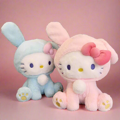 Two plushie toys, one in blue rabbit attire and the other in pink with a bow, resembling the Hello Kitty character.