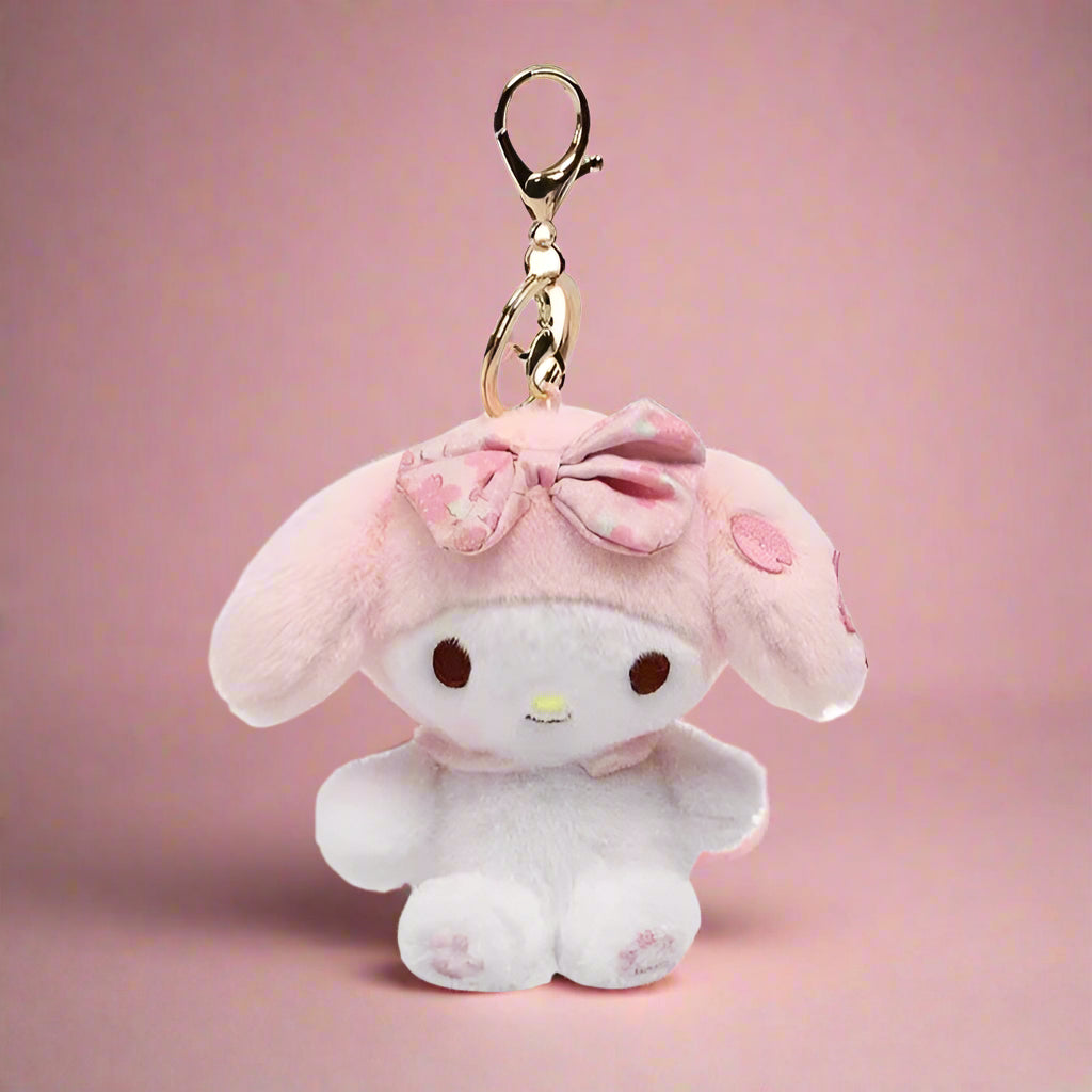 A collection of plush keychains featuring various Sanrio characters, including figures from the My Melody series and other related characters, dressed in colorful, pastel-colored outfits.