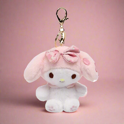 A collection of plush keychains featuring various Sanrio characters, including figures from the My Melody series and other related characters, dressed in colorful, pastel-colored outfits.
