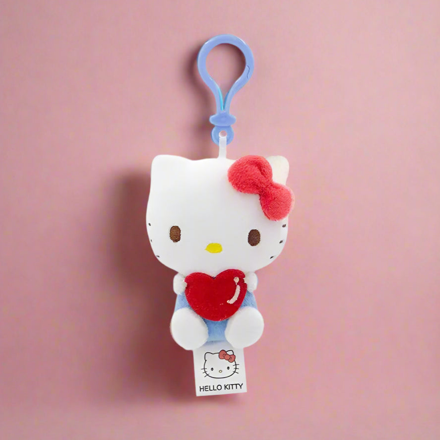 Two plush keychains featuring characters from Sanrio, one designed like a white cat with a blue heart and the other like a white bear with a red heart.