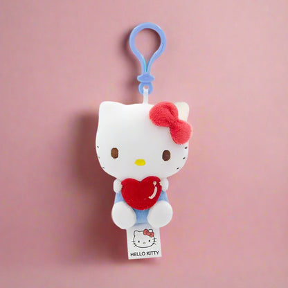 Two plush keychains featuring characters from Sanrio, one designed like a white cat with a blue heart and the other like a white bear with a red heart.