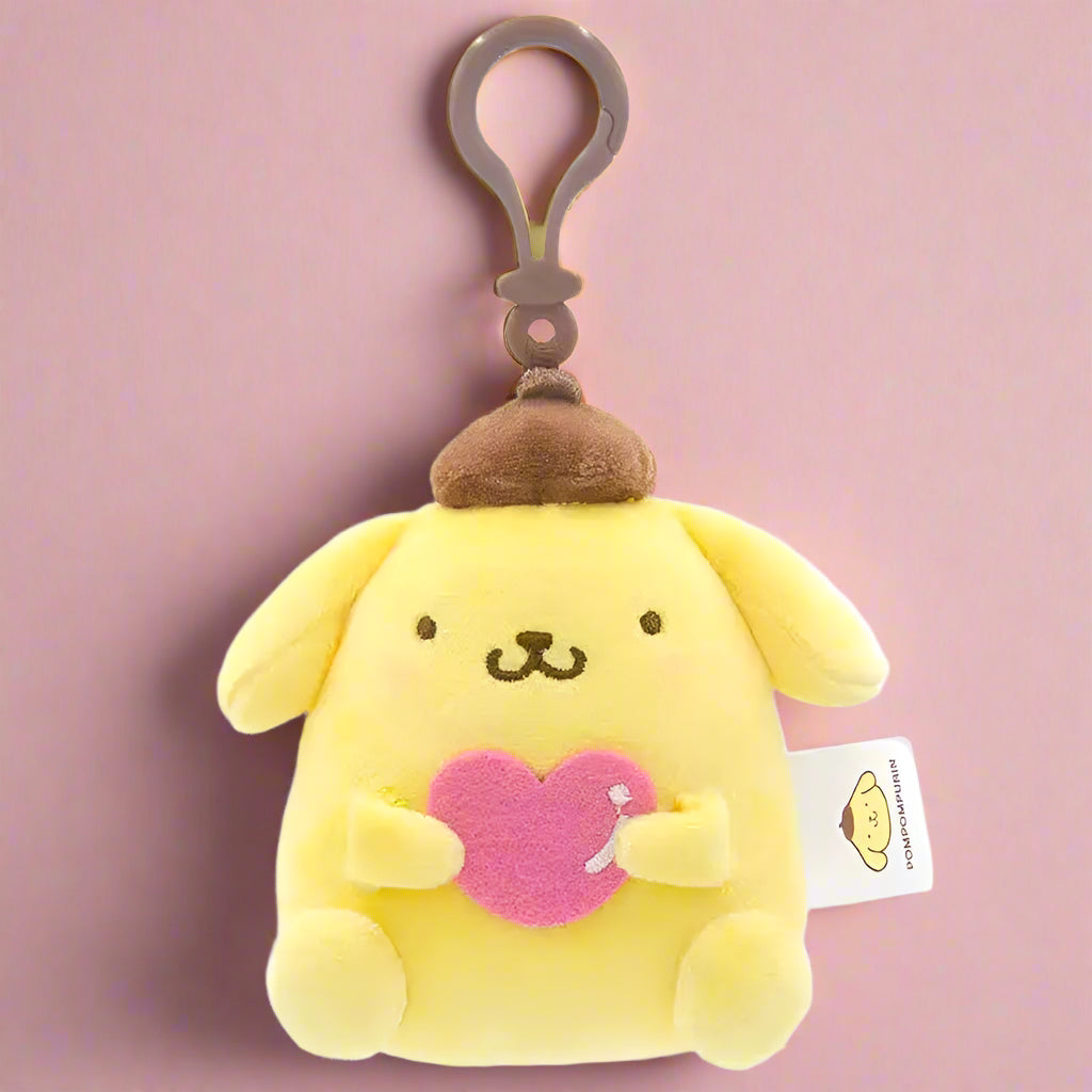 Two plush keychains featuring characters from Sanrio, one designed like a white cat with a blue heart and the other like a white bear with a red heart.