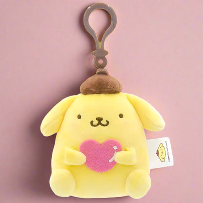 Two plush keychains featuring characters from Sanrio, one designed like a white cat with a blue heart and the other like a white bear with a red heart.