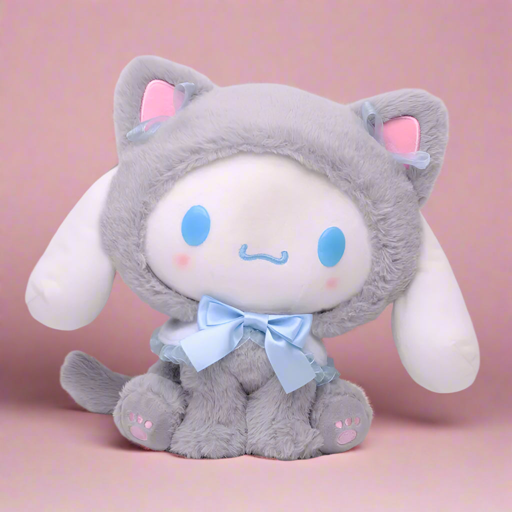 Four different plushies of Sanrio characters, each with distinct colors and designs. Top left is purple with a skull motif, top right is gray with a cat-like appearance, bottom left is pink resembling a rabbit, and bottom right is white and pink resembling a cat with a bow.