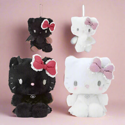 A set of Sanrio Hello Kitty plush toys and keychains from the 'Angel & Devil' Series. One plush is black with a red bow, and the other is white with a pink bow.