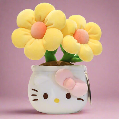 A plush flower bouquet with two flowers, one red and one pink, each with a Hello Kitty character design on the pot. The bouquet is displayed on a white grid surface.