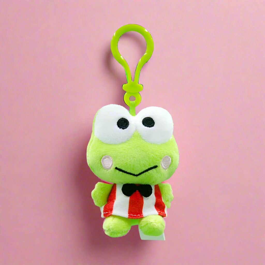 Plush frog toy with a clip on a green background